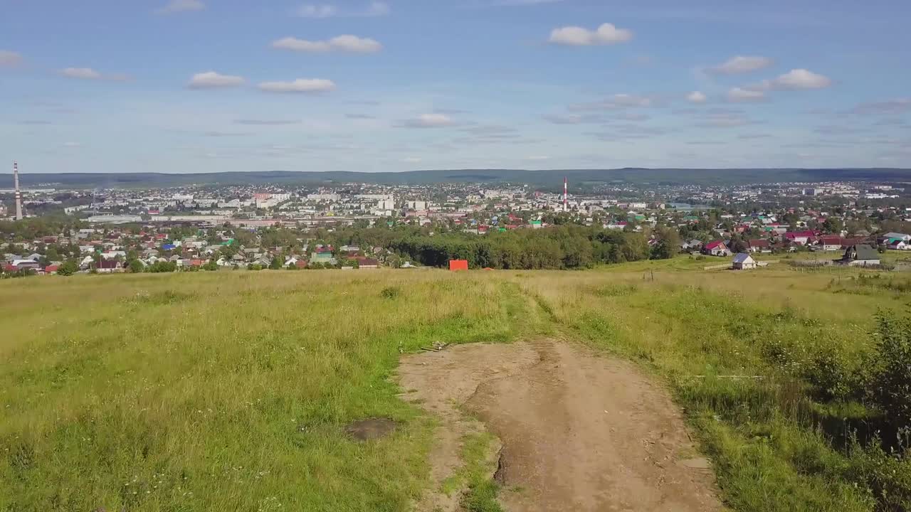 hermoso paisaje urbano - casas tradicionales y mezquita con cúpula verde esmeralda contra el fondo de la cordillera y el cielo azul.
