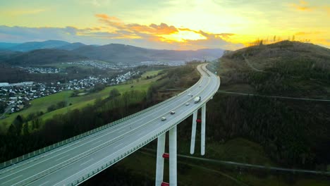 Autos-Y-Camiones-De-La-Hora-Dorada-Cruzando-El-Puente-De-Autopista-Más-Alto-De-Rhine-westfalia-Del-Norte,-Talbrücke-Nuttlar