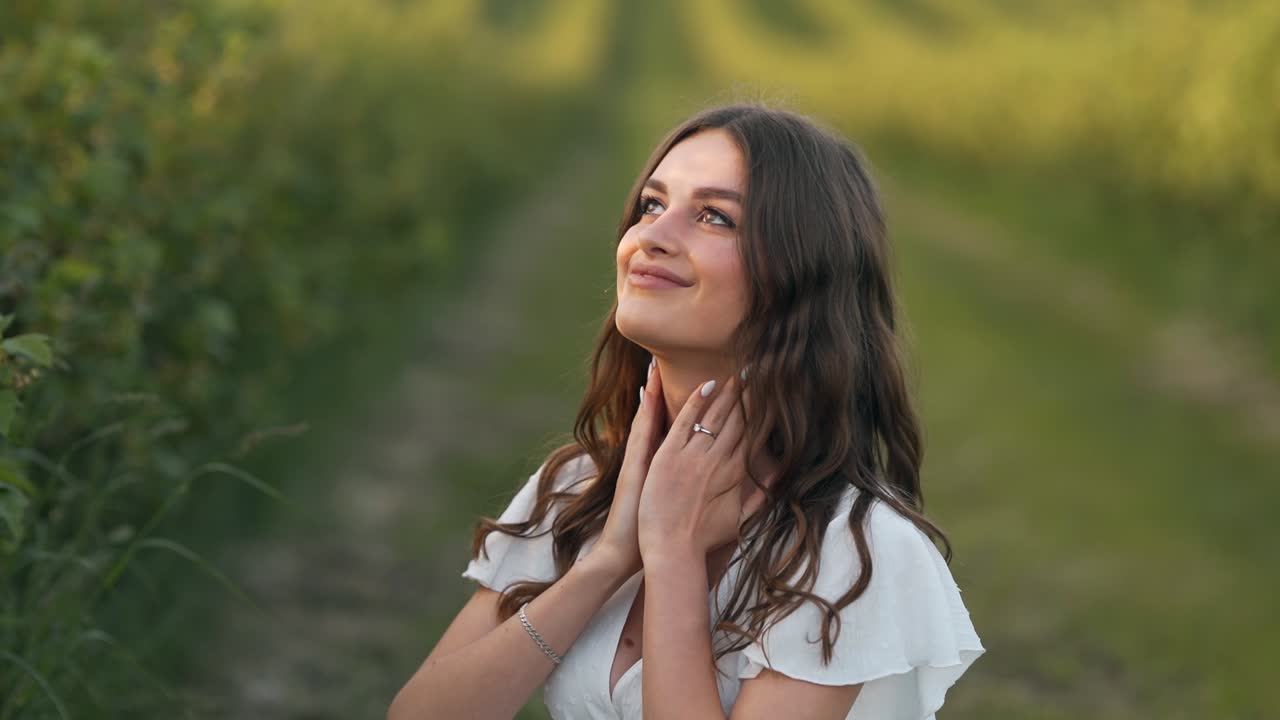 close-up portrait of a woman spraying perfume on herself in nature