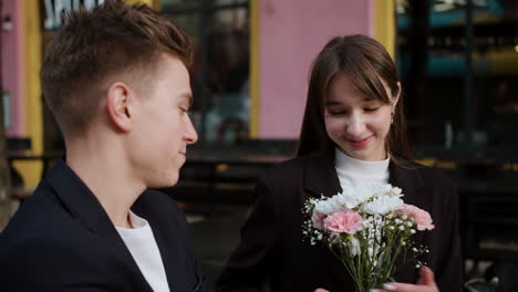 teenage boy giving flower bouquet to girl