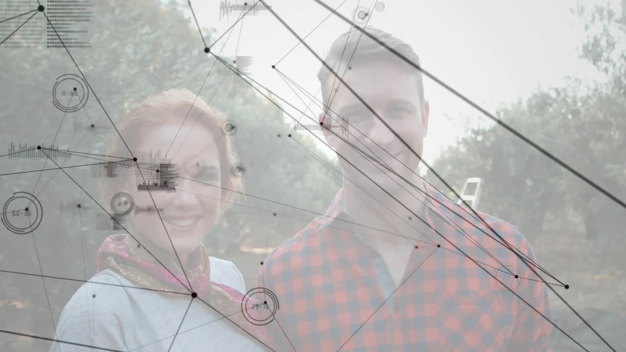Couple standing at dawn in orchard witnessing data grid forming above them for agtech insights
