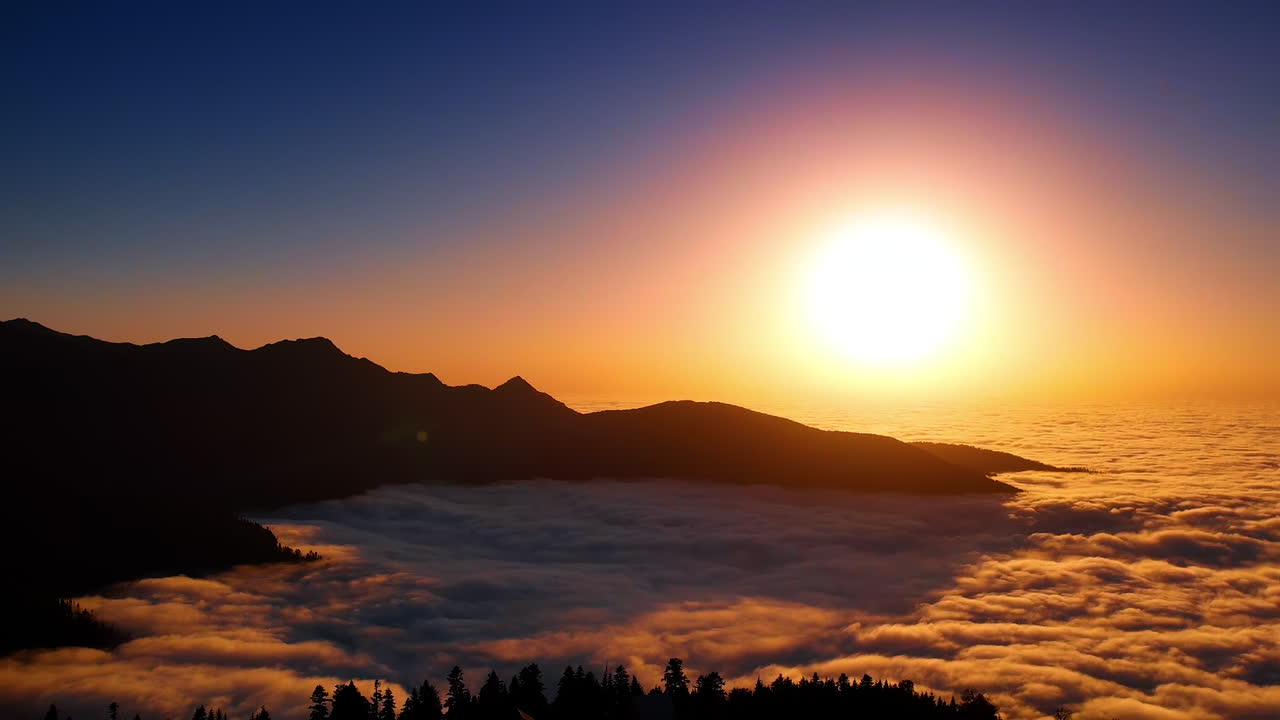 Schönes goldenes Licht der untergehenden Sonne färbt die weite, dichte Wolkenlandschaft. Luftaufnahme der dunklen Felsensilhouetten im Kaukasusgebirge.