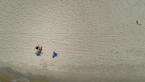 woman with small child goes out of sea and goes across beach