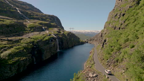 conducción de automóviles en la carretera escénica røldalsfjellet con vistas a la cascada en skare, noruega