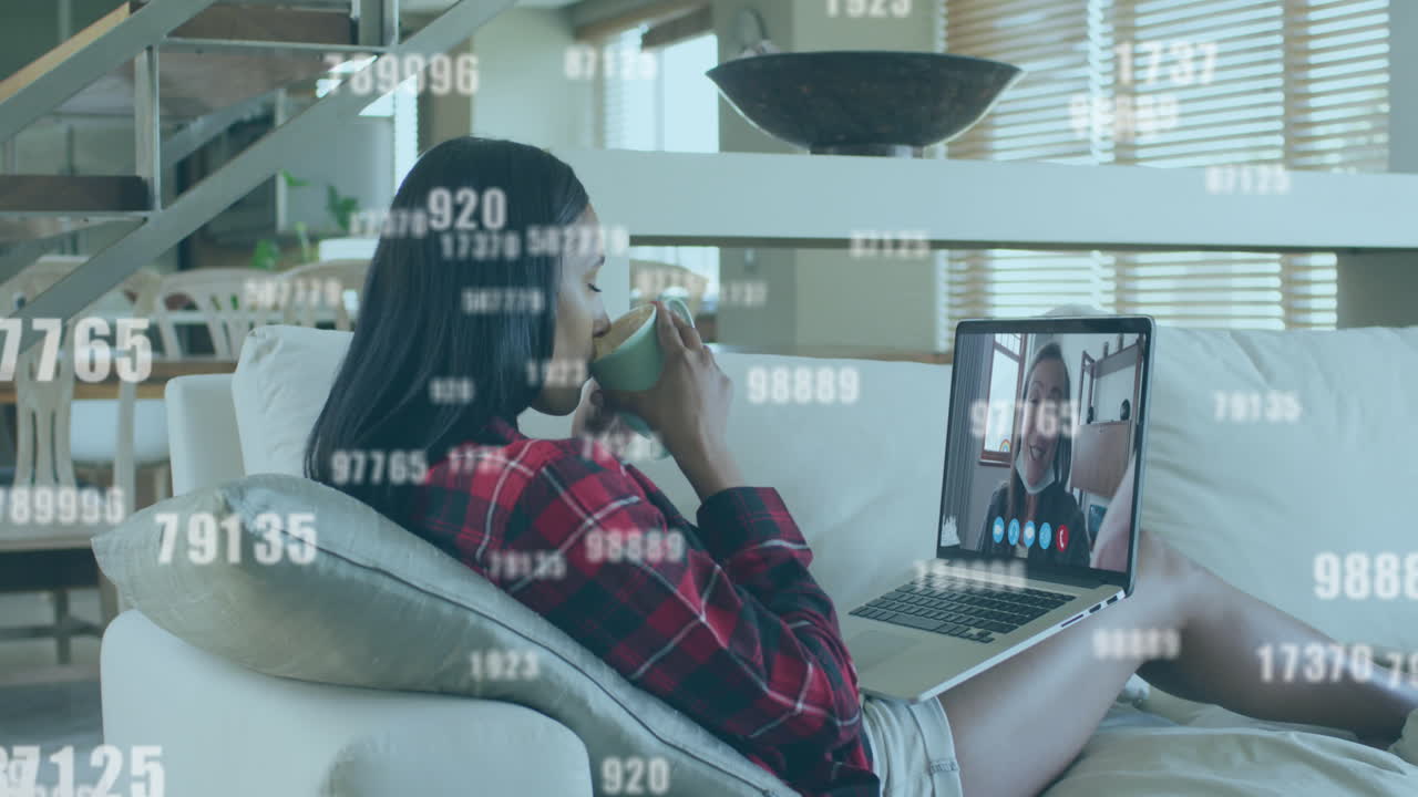 aumento de los números múltiples que caen contra la mujer que tiene una videollamada en la computadora portátil en casa