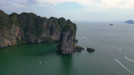 una vista impresionante de una bahía aislada con aguas turquesas, rodeada de altos acantilados cubiertos de exuberante vegetación verde