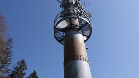 tilt up to a high transmission mast standing in a rural field in switzerland