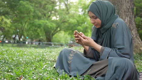 Jóvenes-Musulmanas-Usando-Teléfonos-Inteligentes-En-Un-Parque