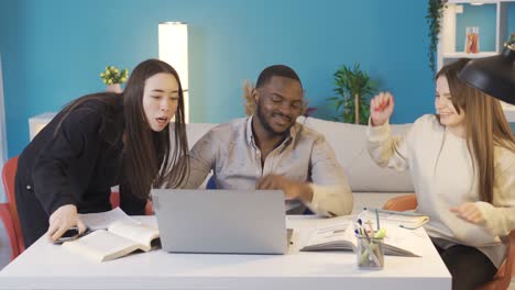 young people of different races sit at the study desk to study.
