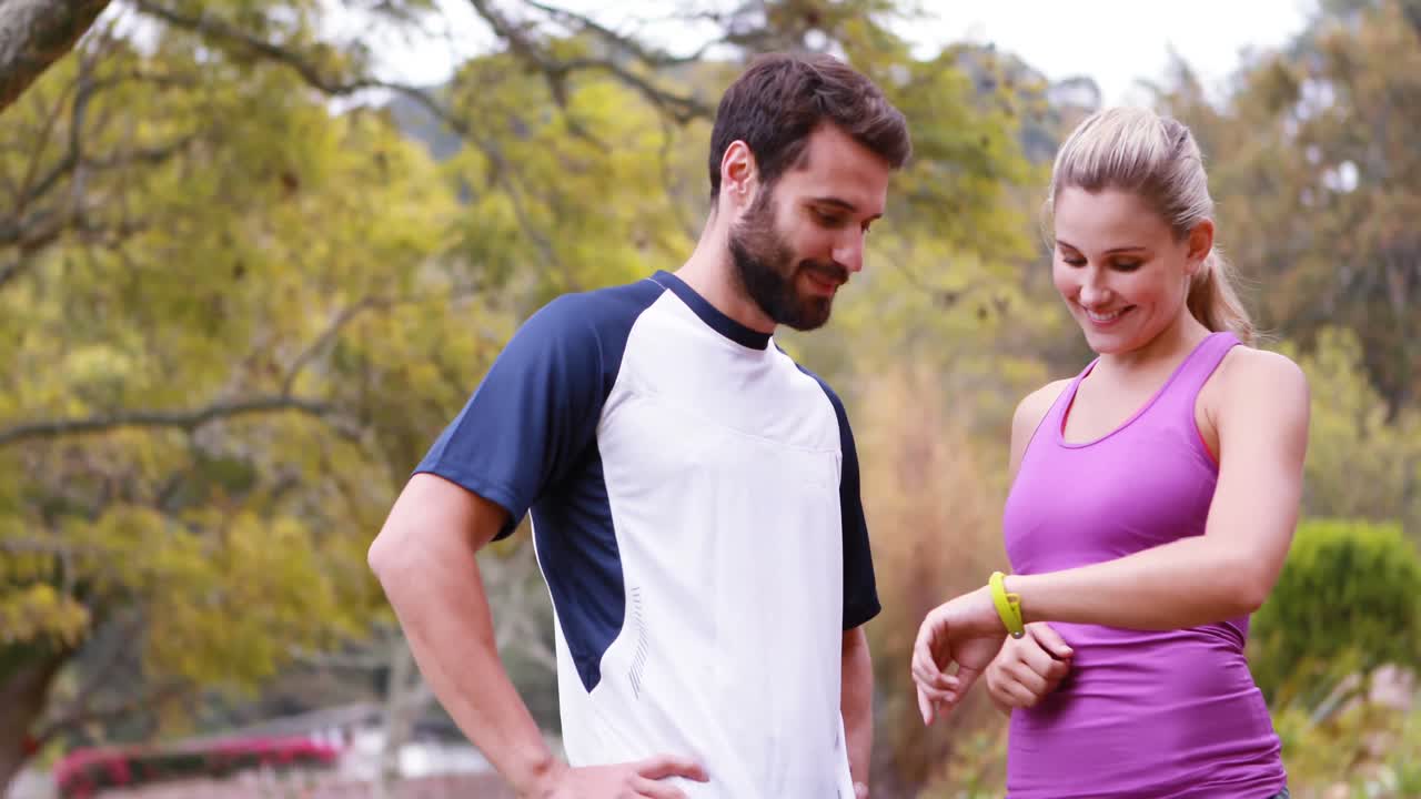 una pareja chequeando una hora en el bosque.