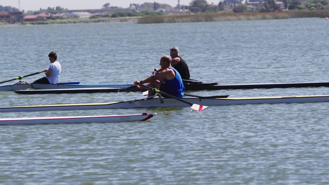 Four senior caucasian men and women rowing boat on a river