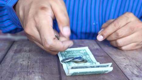 persona que maneja monedas y billetes de dólar