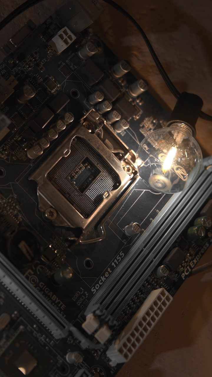 Exposed Motherboard Under Warm Bulbs, Closeup Of Processor Socket And Illuminated Test Lamps On Power Rails. Media