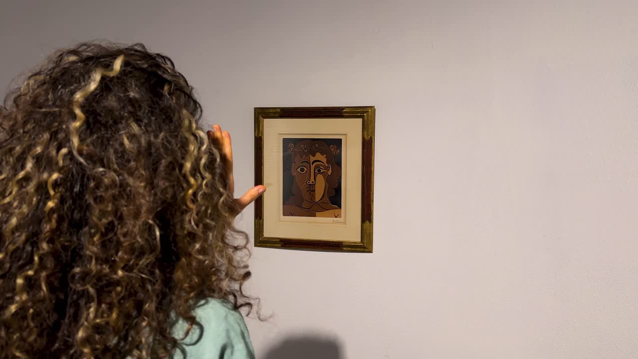 Kunstrahmen an der Wand mit weißem Passepartout. Eine Frau mit lockigem Haar steht als anspruchsvolle Betrachterin mit elegantem Lächeln in einer künstlerischen, zeitgenössischen Kreativausstellungsgalerie.