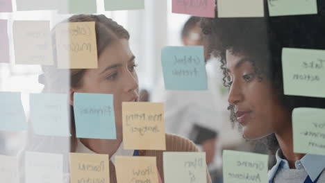 creative business women using sticky notes brainstorming colleagues working together problem solving discussing solution enjoying teamwork in startup office