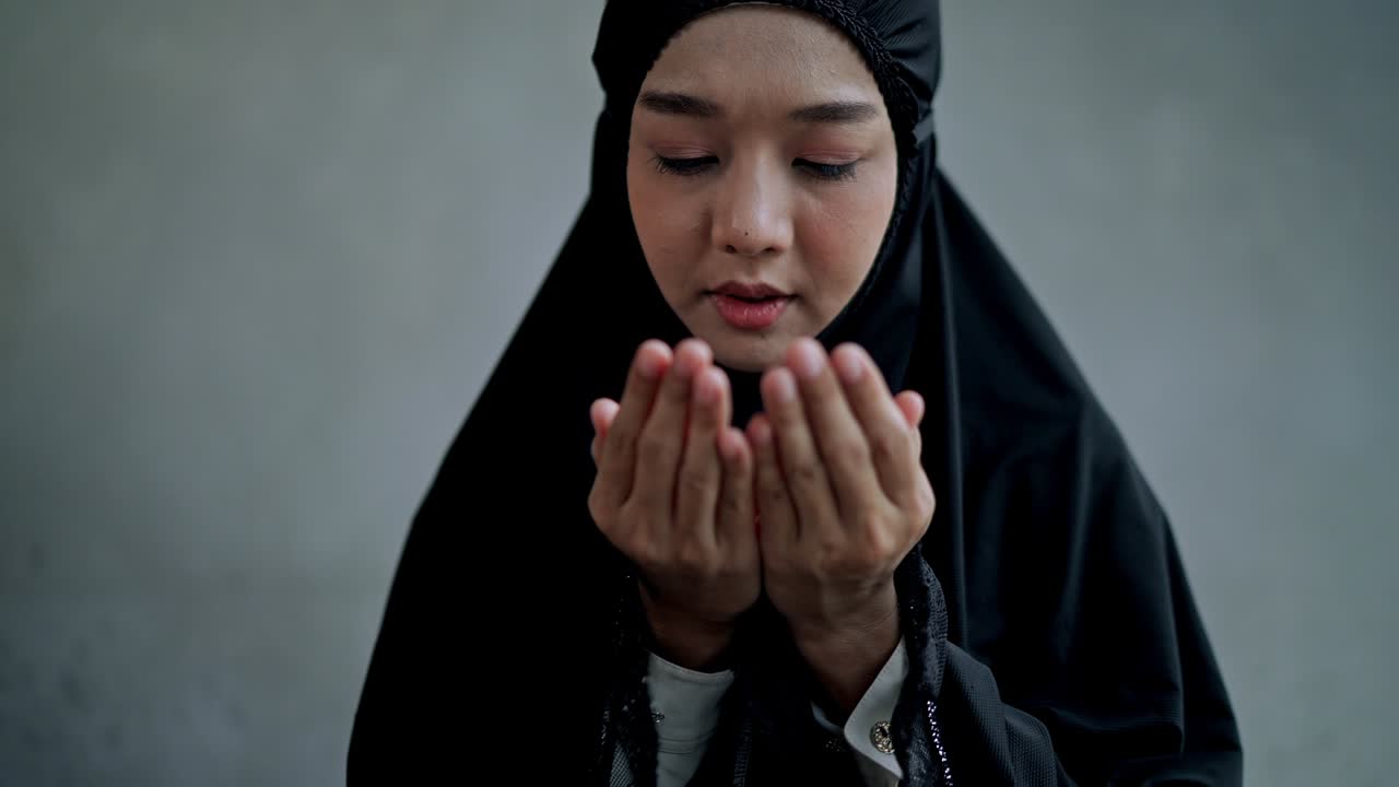집에서 기도하는 아시아 젊은 무슬림 여성