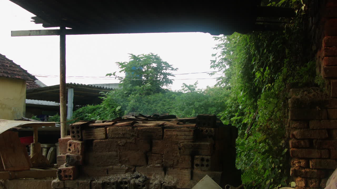 베트남 꽝남성의 탄하 도자기 마을은 나무 화덕에서 연기가 피어오르는 전통 도자기, 눈에 보이는 열, 녹색 덤불을 선보입니다.