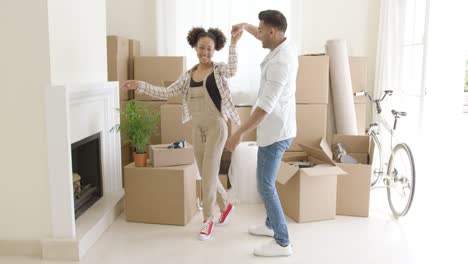 mixed race couple dancing in new home