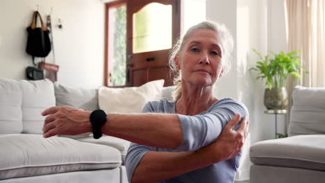 Senior woman relaxing at home, embracing self with peaceful expression