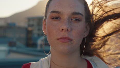 portrait-redhead-woman-with-freckles-looking-serious-with-wind-blowing-hair-teenage-girl-in-city-at-sunset-self-image-testimonial-concept