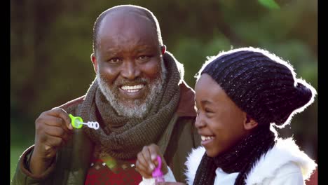 grandfather and girl blowing bubbles