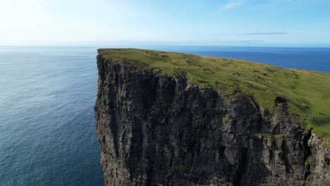 hikkers in traelanipa huge cliffs in faroe islands, north atlantic ocean