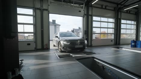 amplio taller automotriz con ascensores de vehículos, herramientas, estaciones de trabajo y mecánicos trabajando. espacio industrial brillante diseñado para la reparación y mantenimiento de automóviles