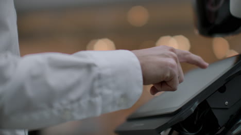 a man stands with a robot bot and asks him questions and asks for help by clicking on the screen on the robot body. human-robot interaction in the modern world