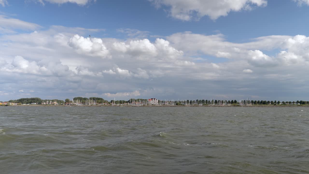 Calm sea with sailboats and a cloudy sky