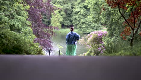 wide shot of young women walking towards a river base and turning at the end