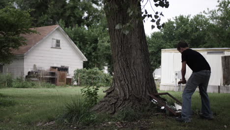 a young high school aged teen boy uses an axe to break a mirror