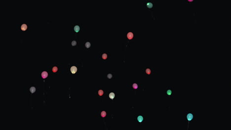 pastel balloons ascending adrift in night sky