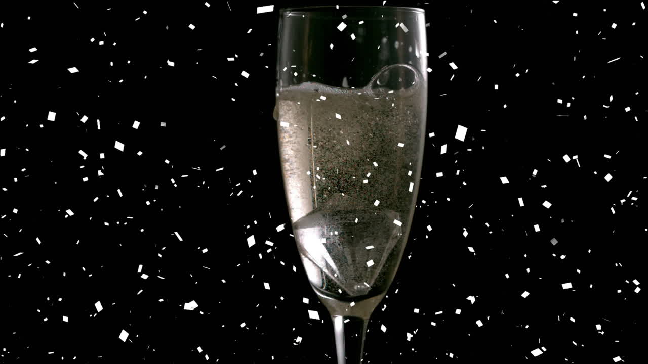 animación de confeti cayendo y champán vertiendo en un vaso de champán sobre un fondo negro