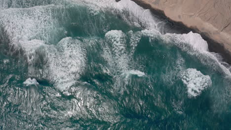 aerial: big waves in vlychada beach of santorini, greece, 4k prores