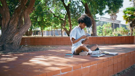 cute teenager reading smartphone message sitting street. teen girl looking cell