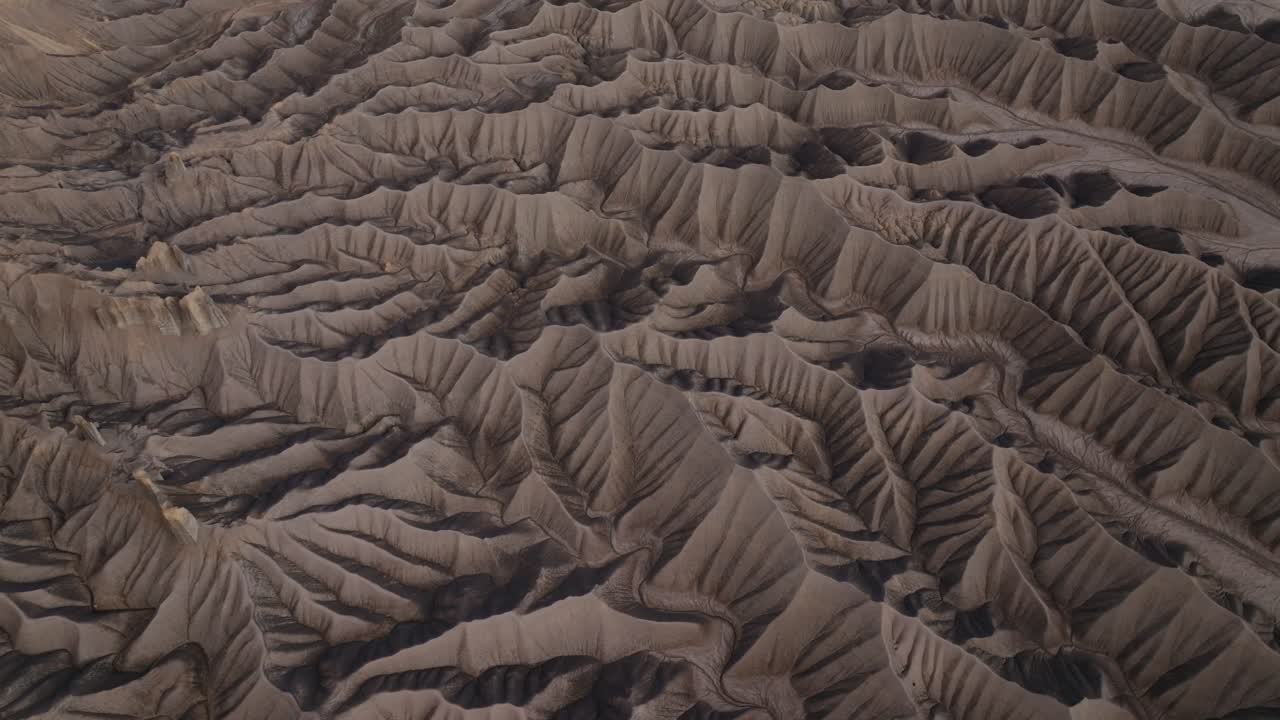 Textured desert badlands ridges and erosion lines across arid terrain near Factory Butte Utah, drone