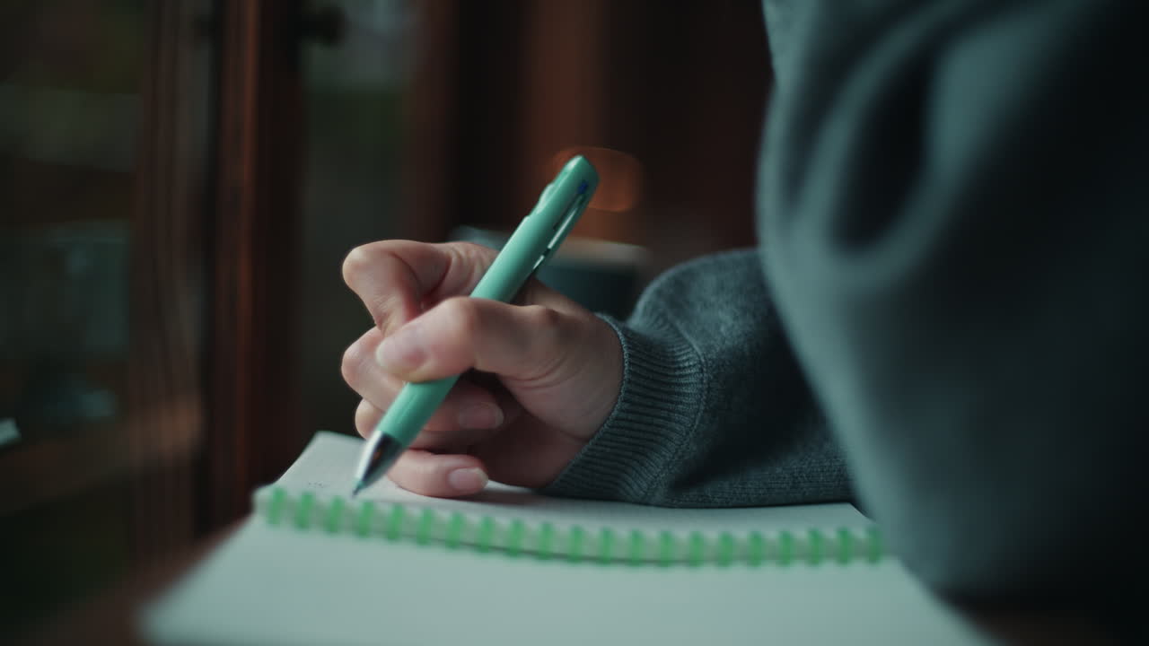 Close-up of hand writing in a notebook