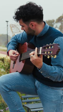 hombre tocando la guitarra acústica al aire libre