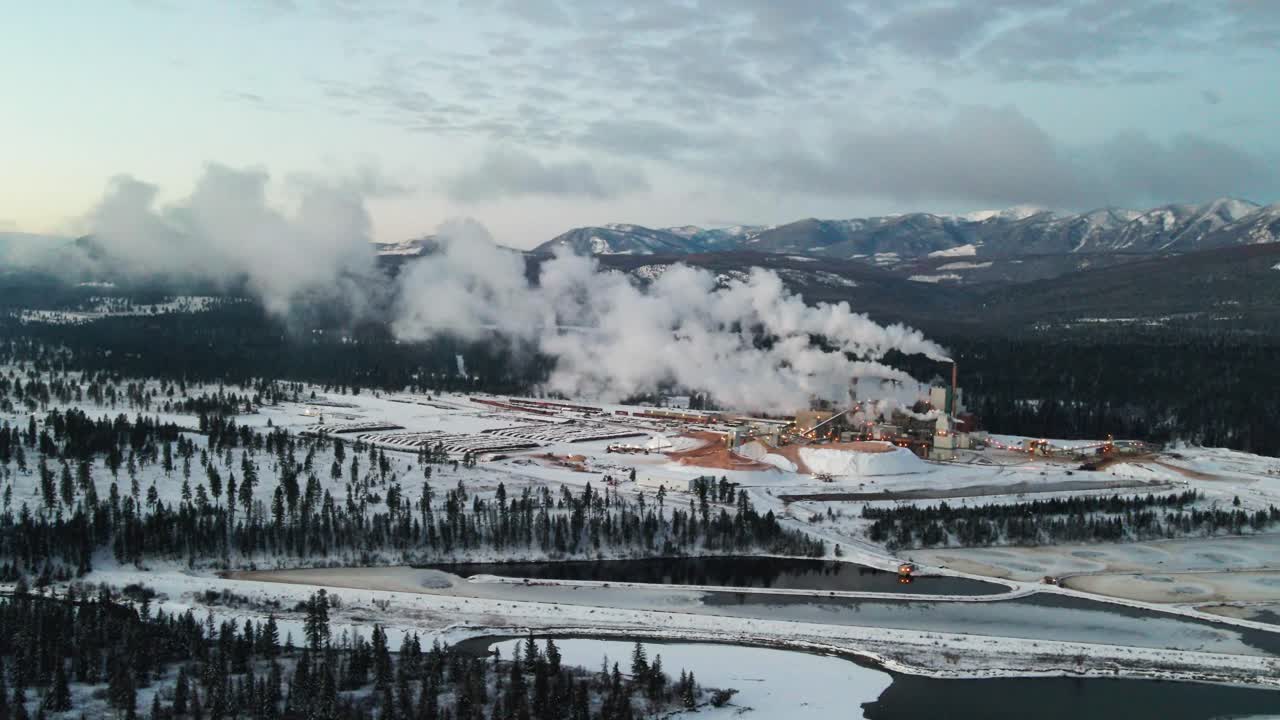 fábrica de pulpa en acción: vista aérea de las instalaciones industriales emisoras de contaminación en cranbrook, columbia británica, procesando materias primas para la producción de papel en un frío día de invierno