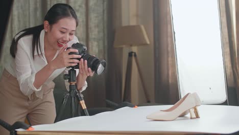 asian female photographer celebrating succeed taking photos of women's shoes in home studio