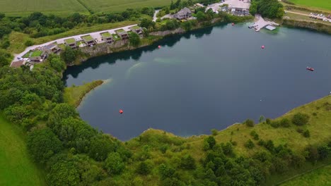 panning drone shot of diving reservoir with eco homes