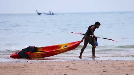 man prepares kayak on krabi beach