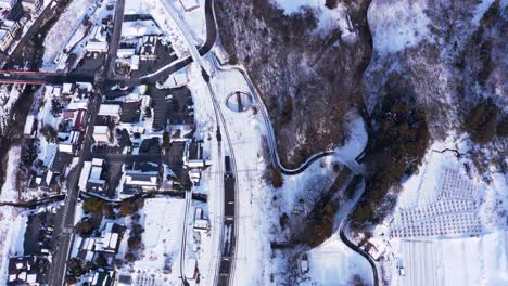 Aerial-View-of-Snowy-Landscape-of-Yamagata-Japan,-Small-Town-and-Mountains