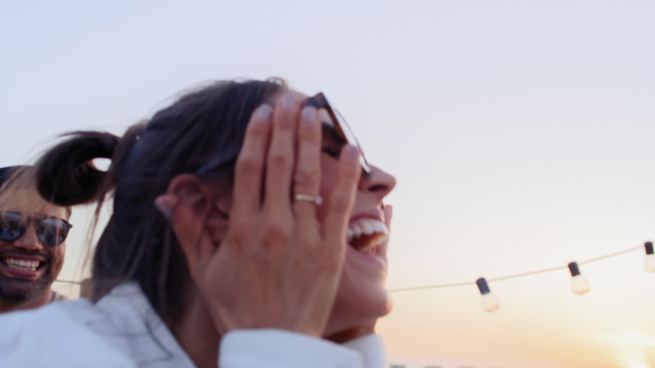 친구들이 해가 지는 동안 옥상 파티에서 함께 춤을 추고 있습니다.