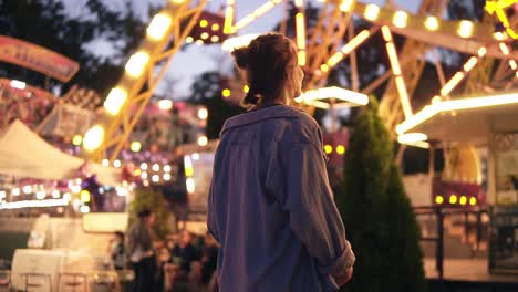 Side-Portrait-Of-An-Attractive-Young-Couple-Meeting-In-An-Amusement-Park-With-A-Colorful,-Brightful-Sights