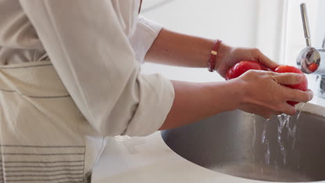 Hands,-tomato-and-washing-with-a-woman-cook