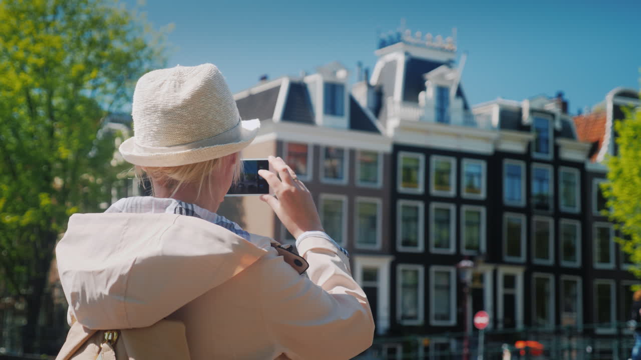 암스테르담에서 건물 사진을 찍는 여자
