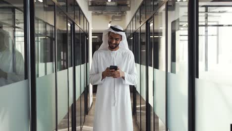 handsome man and woman with traditional clothes working in an office of dubai