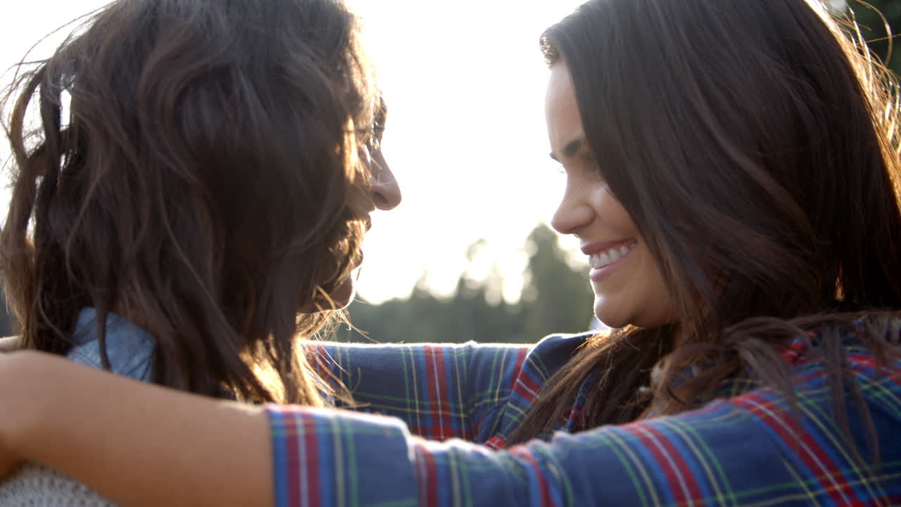 una pareja de lesbianas se abrazan tocando las narices, los ojos cerrados, de cerca