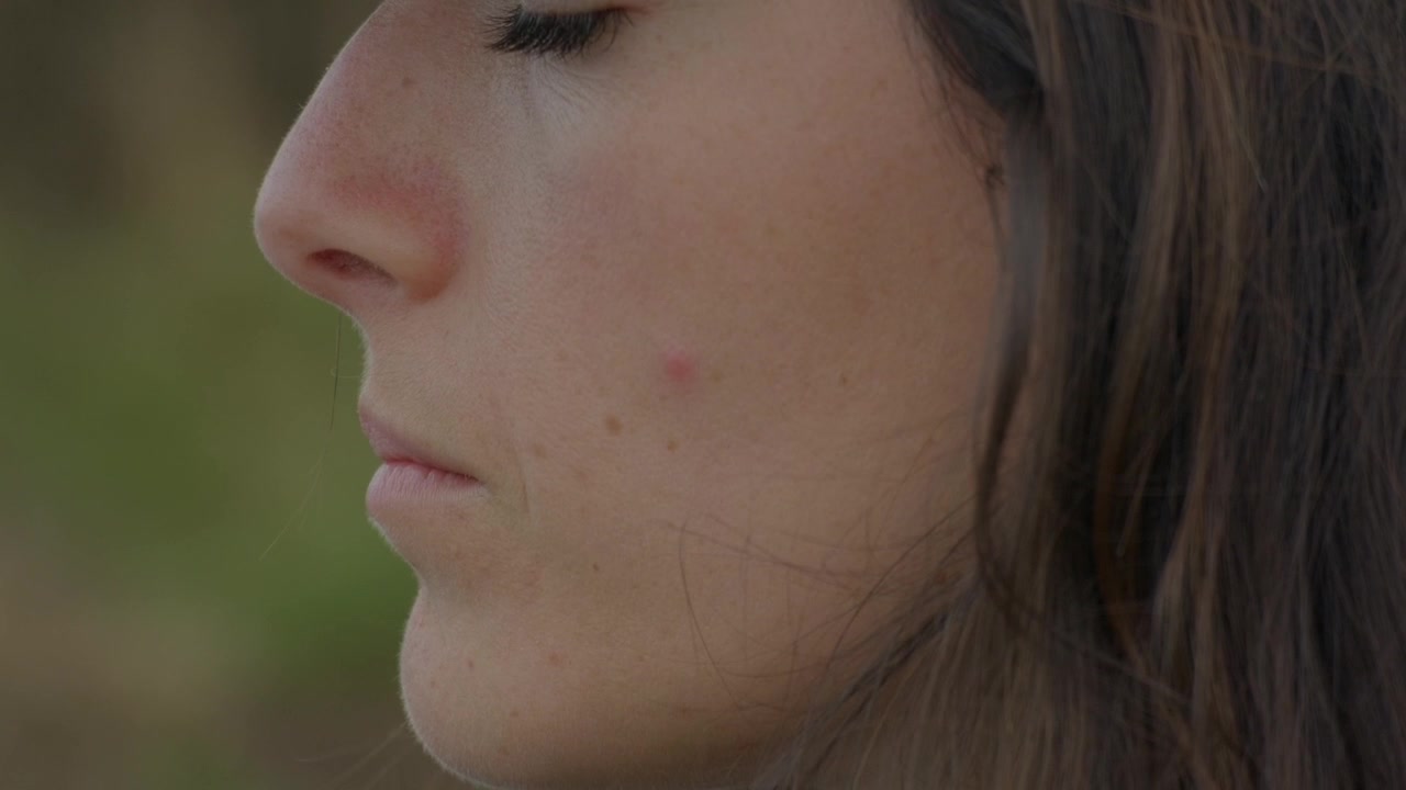 Primo piano di una giovane donna che si gode un momento di calma all'aperto.
